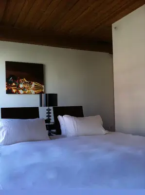 a bedroom with a white bed and a painting on the wall at Hotel Ocho in Toronto