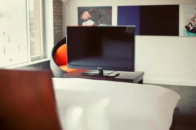 a flat screen tv sitting on top of a couch at Hotel Ocho in Toronto