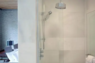 a bathroom with a shower with a glass door at Hotel Ocho in Toronto