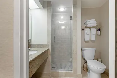 a bathroom with a toilet and a sink and a shower at Best Western Plus Otonabee Inn in Peterborough