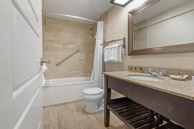 a bathroom with a sink and a toilet and a tub at Best Western Plus Otonabee Inn in Peterborough