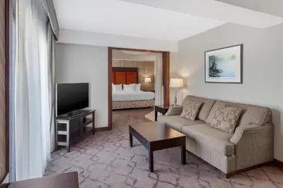 a living room with a couch and a television and a bed at Best Western Plus Otonabee Inn in Peterborough