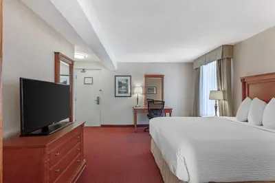 a hotel room with a bed and a flat screen tv at Best Western Plus Otonabee Inn in Peterborough