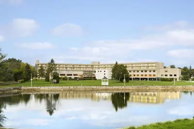 a large building with a lake in front of it at Ramada by Wyndham Belleville Harbourview Conference Center in Belleville