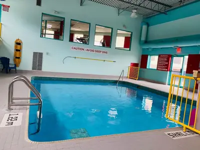 a large swimming pool with blue water in a building at Ramada by Wyndham Belleville Harbourview Conference Center in Belleville