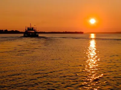 a boat on the water at sunset at Ramada by Wyndham Belleville Harbourview Conference Center in Belleville