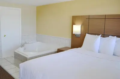a hotel room with a bed and a bath tub at Motel 6 Campbellford, ON in Campbellford