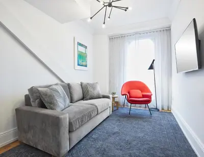 a living room with a couch and a red chair at The Walper Hotel, part of JdV by Hyatt in Kitchener