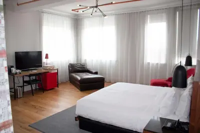a bedroom with a bed and a chair and a television at The Walper Hotel, part of JdV by Hyatt in Kitchener