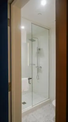 a glass shower in a bathroom with a toilet at The Walper Hotel, part of JdV by Hyatt in Kitchener