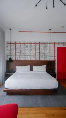 a bedroom with a large bed and a red wall at The Walper Hotel, part of JdV by Hyatt in Kitchener