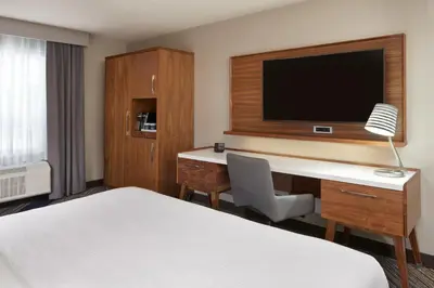 a hotel room with a bed and a desk with a television at Four Points by Sheraton Vaughan in Vaughan