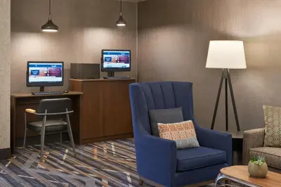 a living room with a blue chair and a television at Four Points by Sheraton Vaughan in Vaughan