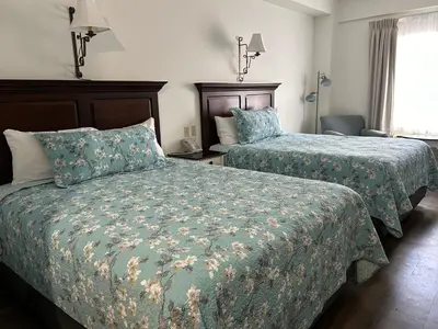 a hotel room with two beds and a window at The Village Inn of Lakefield in Lakefield