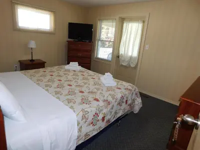 a hotel room with a bed and a television at Rainbow Bed & Breakfast in Niagara Falls