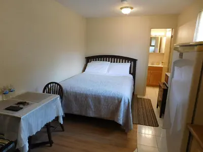 a bedroom with a bed and a table in it at Rainbow Bed & Breakfast in Niagara Falls