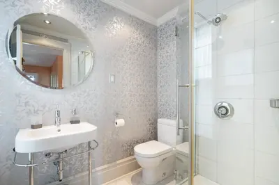 a bathroom with a toilet and a sink and a mirror at Lion's Head B&B in Niagara Falls