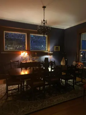 a dining room with a table and chairs and a chandelier at Lion's Head B&B in Niagara Falls