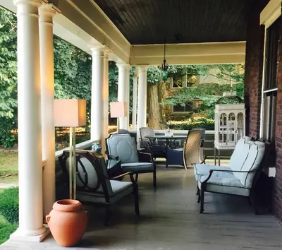 a porch with chairs and tables on a house at Lion's Head B&B in Niagara Falls