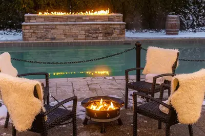 two chairs and a fire pit in front of a pool at Pillar and Post Inn & Spa in Niagara on the Lake