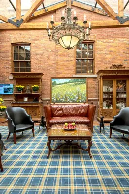 a living room with a couch and chairs and a chandelier at Pillar and Post Inn & Spa in Niagara on the Lake
