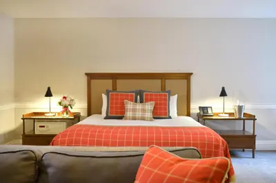 a bedroom with a bed with orange and blue pillows at Pillar and Post Inn & Spa in Niagara on the Lake