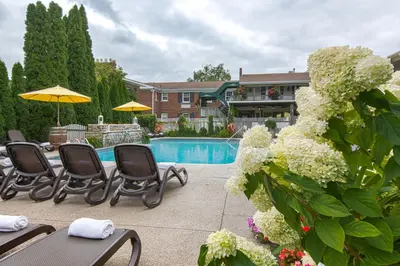 a patio with chairs and a pool and a house at Pillar and Post Inn & Spa in Niagara on the Lake