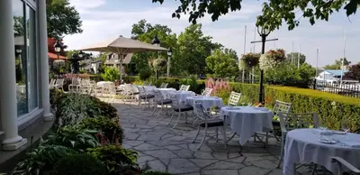 a row of tables and chairs with white table cloths at Queens Landing in Niagara on the Lake