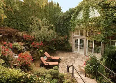a patio with two chairs and flowers in a yard at Queens Landing in Niagara on the Lake