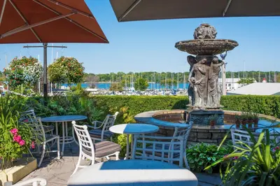 a fountain with blue tables and chairs in a patio at Queens Landing in Niagara on the Lake