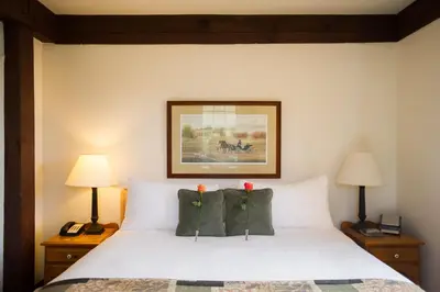 a bedroom with a white bed with two red flowers on the pillows at Millcroft Inn & Spa in Alton