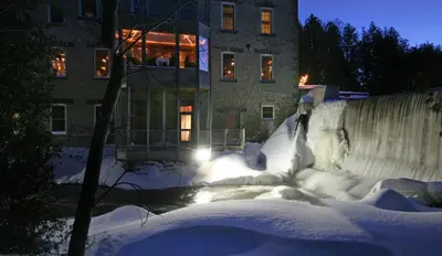 a building with a snow covered yard at night at Millcroft Inn & Spa in Alton