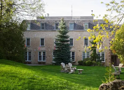 a large brick building with chairs in the yard at Millcroft Inn & Spa in Alton
