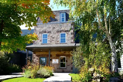 a stone house with trees in front of it at Millcroft Inn & Spa in Alton