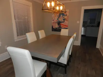 a dining room with a table and white chairs at Kings Inn Near the Falls in Niagara Falls