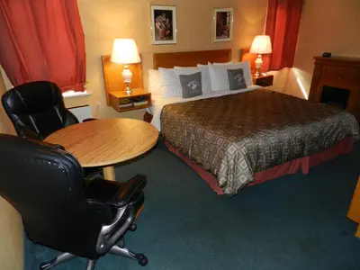 a hotel room with a bed and a table and chairs at Kings Inn Near the Falls in Niagara Falls