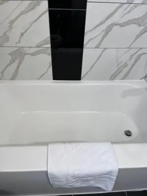 a white towel sitting on top of a bathroom sink at Knights Inn - Park Villa Motel, Midland in Midland