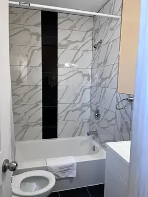 a bathroom with a tub and a toilet and a sink at Knights Inn - Park Villa Motel, Midland in Midland