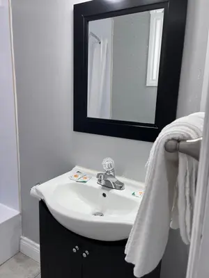 a bathroom with a white sink and a mirror at Knights Inn - Park Villa Motel, Midland in Midland