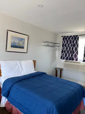 a bedroom with a blue bed and a window at Knights Inn - Park Villa Motel, Midland in Midland