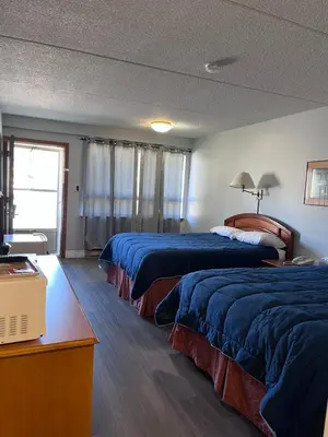 a hotel room with two beds and a television at Knights Inn - Park Villa Motel, Midland in Midland