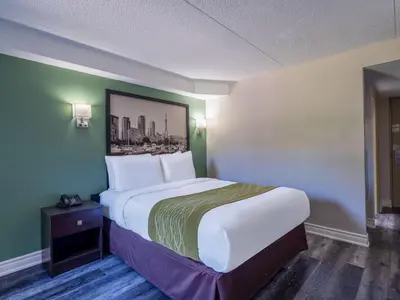 a bedroom with a large bed with a picture on the wall at Super 8 by Wyndham Toronto East ON in Toronto
