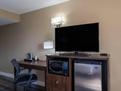 a hotel room with a tv and a microwave at Super 8 by Wyndham Toronto East ON in Toronto