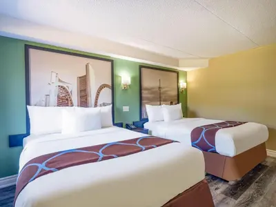 a hotel room with two beds and a painting on the wall at Super 8 by Wyndham Toronto East ON in Toronto
