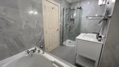 a bathroom with a tub and a shower and a sink at Bedham Hall B&B in Niagara Falls