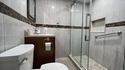 a bathroom with a toilet and a glass shower at Bedham Hall B&B in Niagara Falls