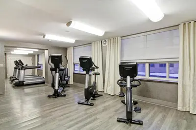 a gym with treadmills and ellipticals in a room at The Park Hotel London in London