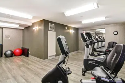 a gym with treadmills and exercise bikes in a room at The Park Hotel London in London