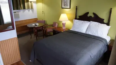a hotel room with a bed and a table and chair at Robyn's Motel in Peterborough