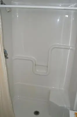 a white shower in a bathroom next to a shower at Robyn's Motel in Peterborough